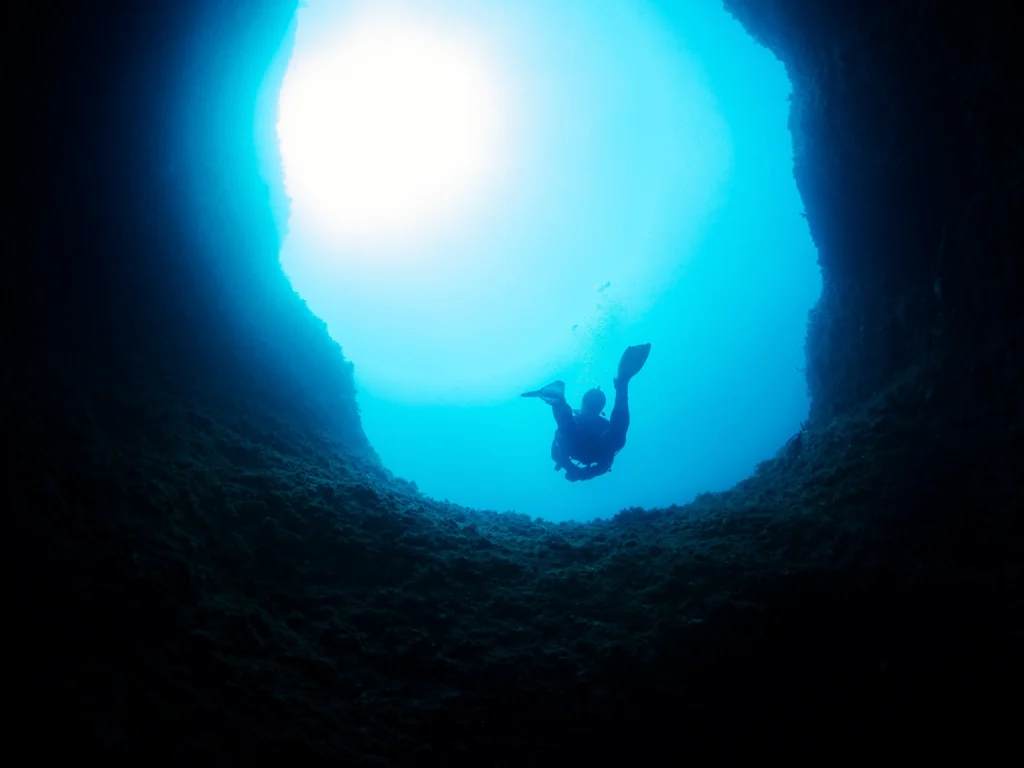silhouette-of-scuba-diver-diving-in-dark-cave